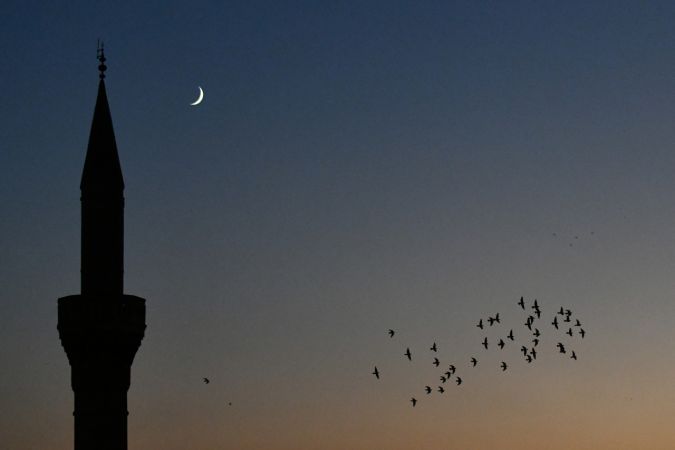 Gaziantep'te  gün batımından hemen sonra görünen hilal, cami minaresi ve kuşlarla güzel görüntü oluşturdu. 2