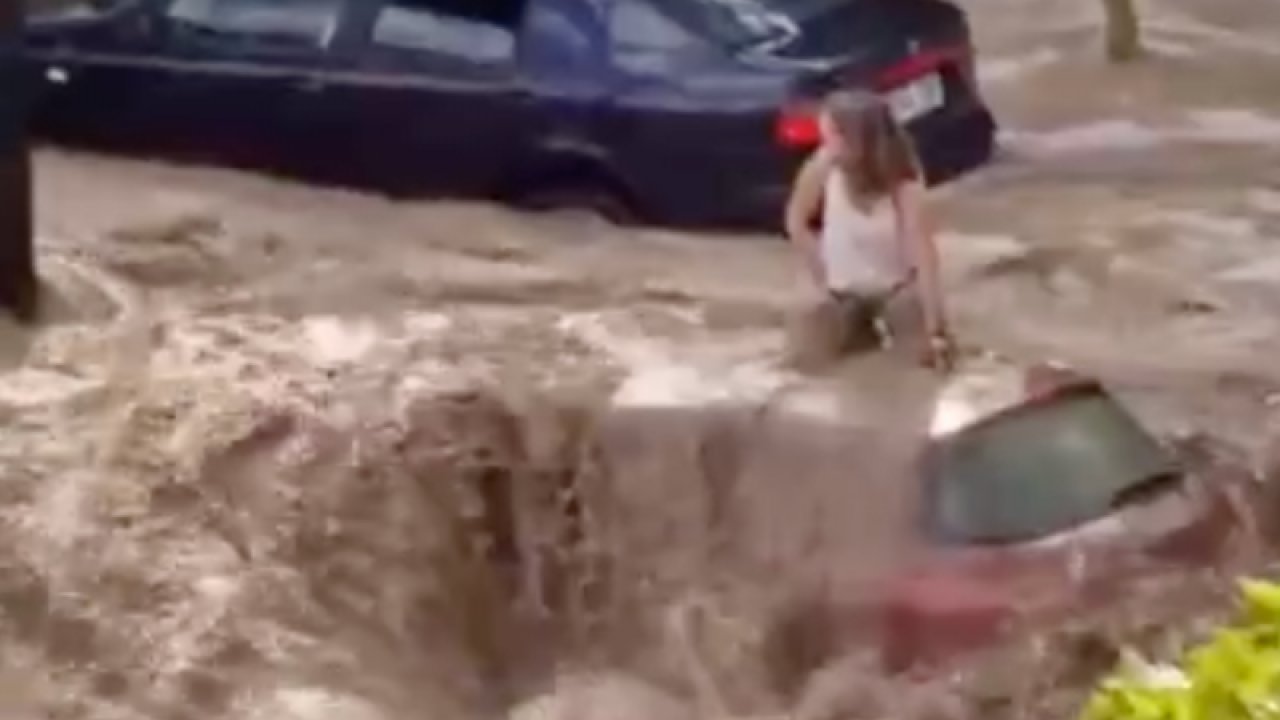 Sel sularında mahsur kalan bir kişi aracın üzerinde yardım bekledi